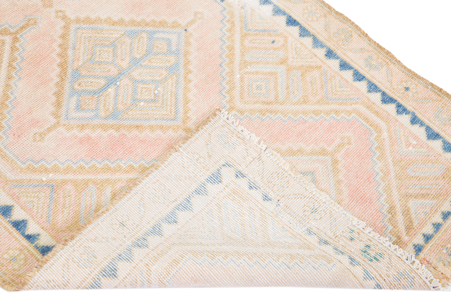 Close up of beige wool runner rug with repeating diamond motif