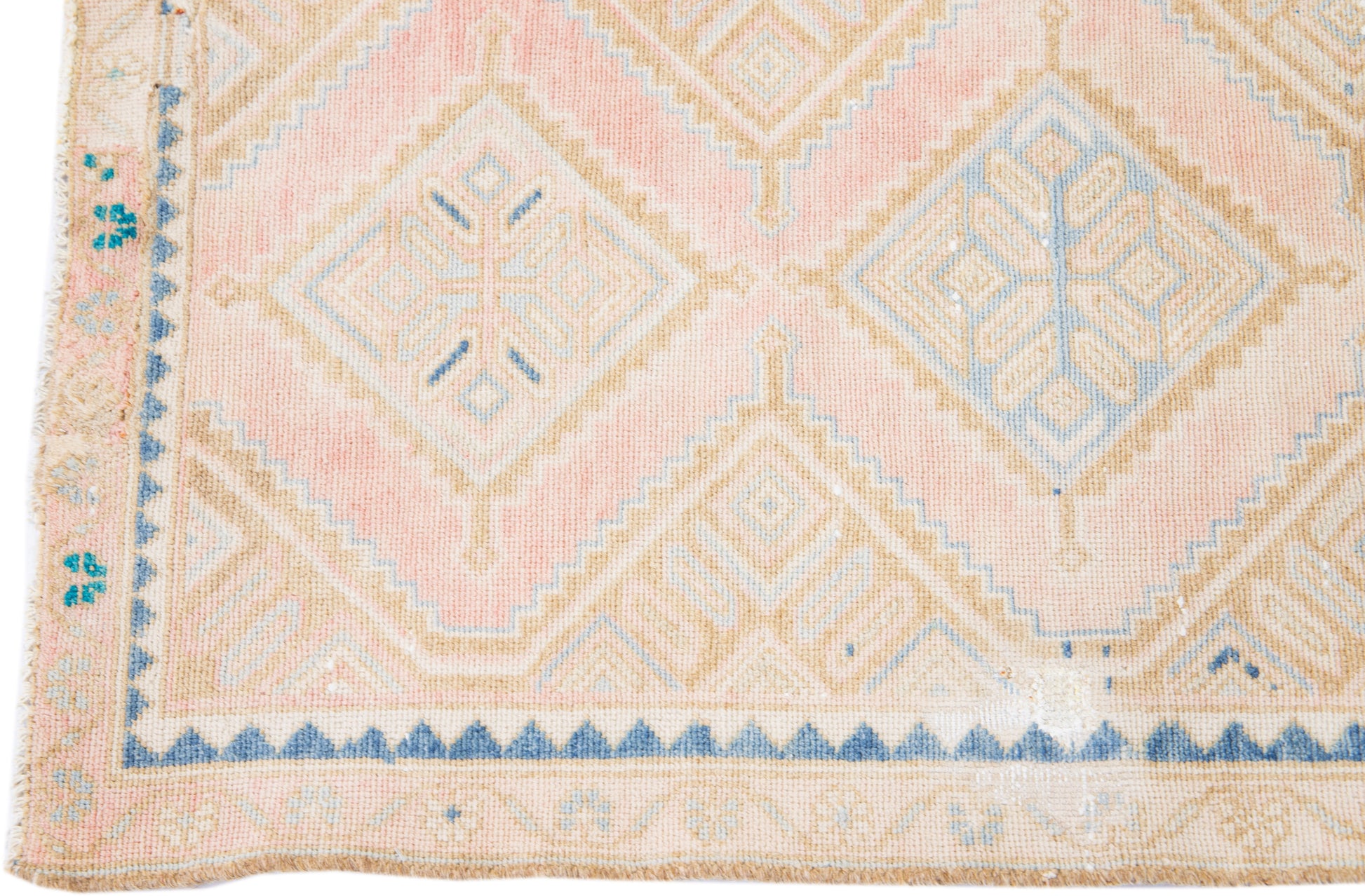 Close up of beige wool runner rug with repeating diamond motif