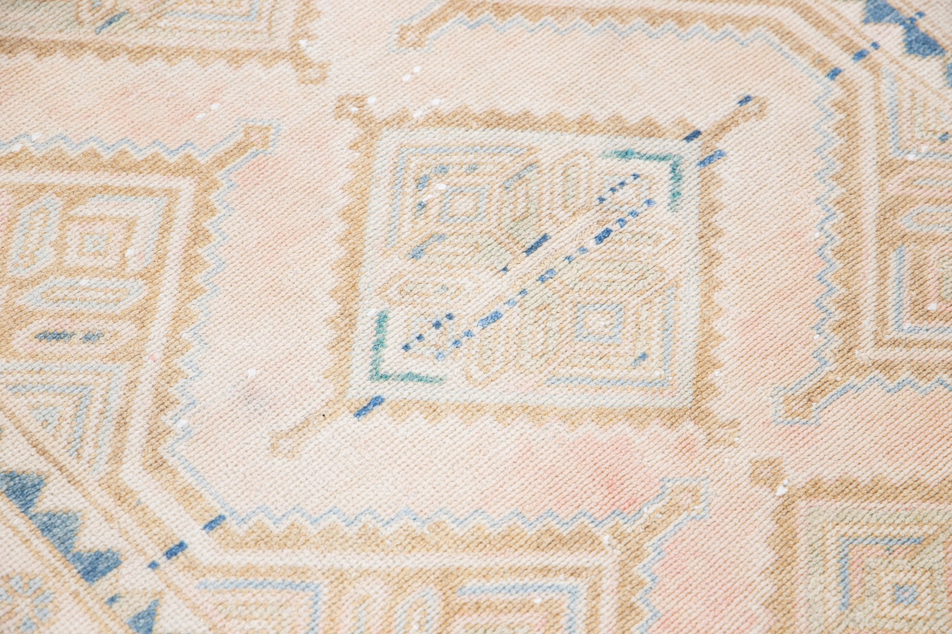 Close up of weave work of beige wool runner rug with repeating diamond motif