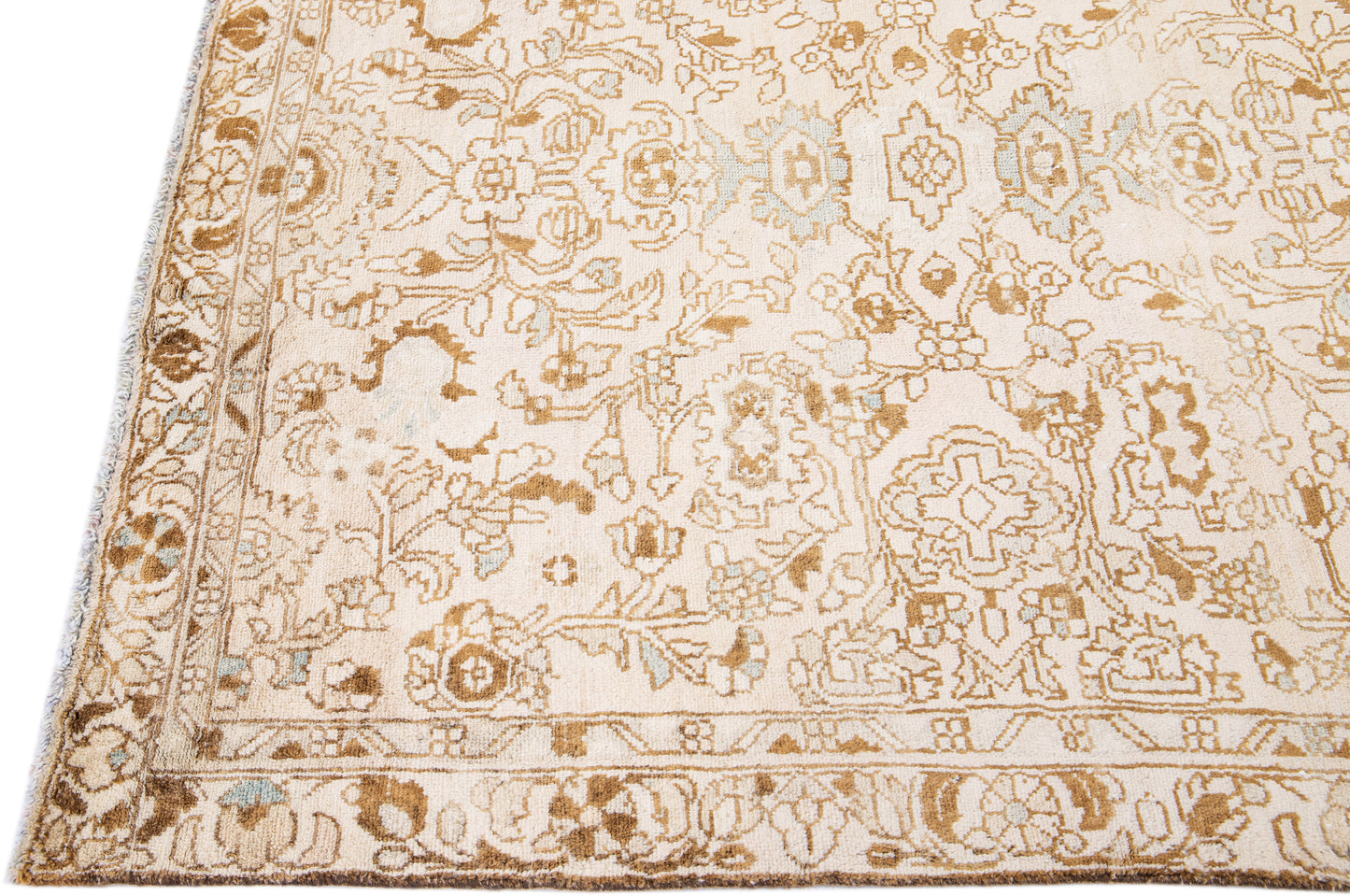 Close up of beige wool rug with floral designs and interwoven patterns