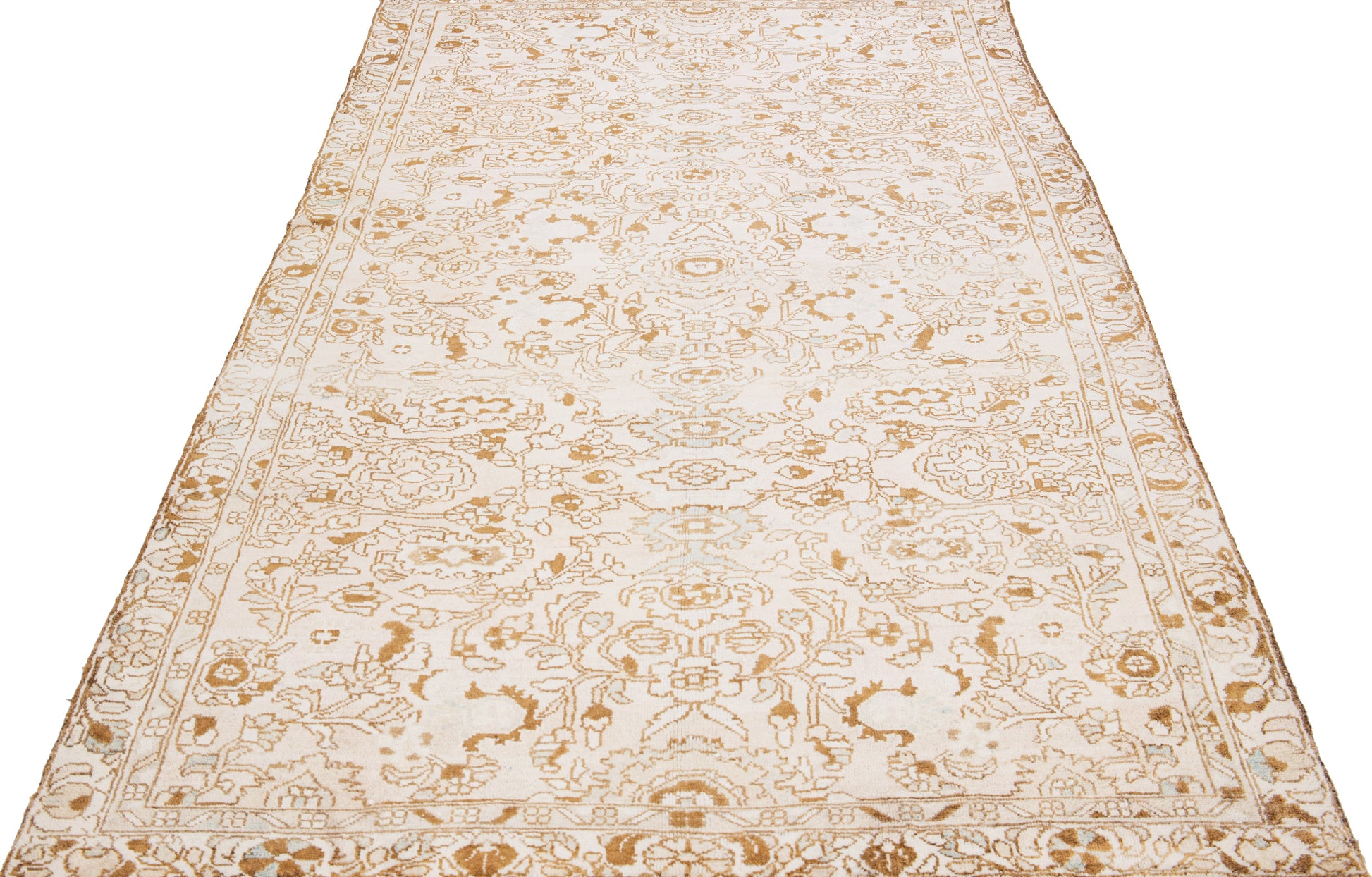 Zoomed out view of beige wool rug with floral designs and interwoven patterns